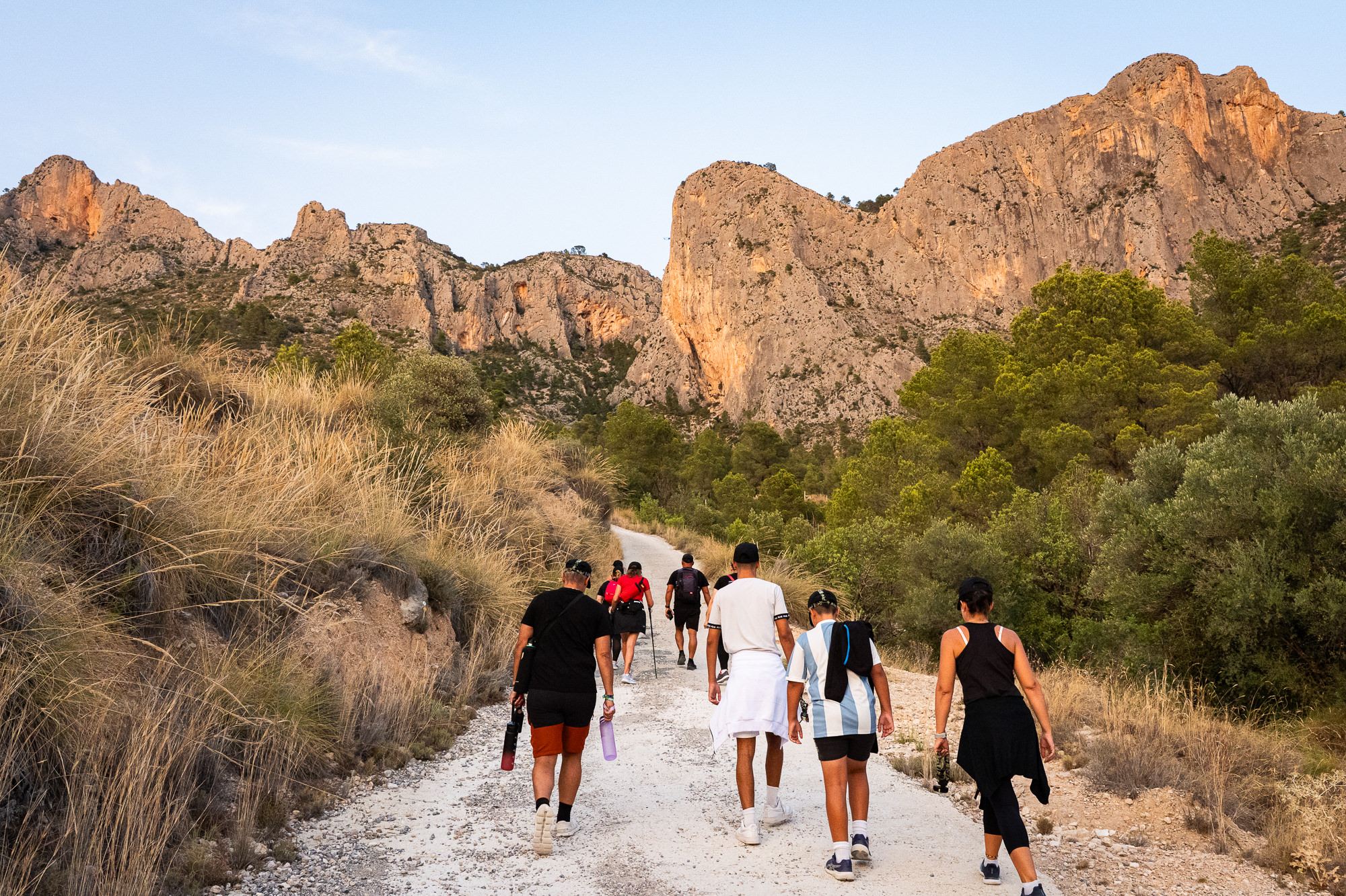Grupo caminando por un sendero rocoso de montaña