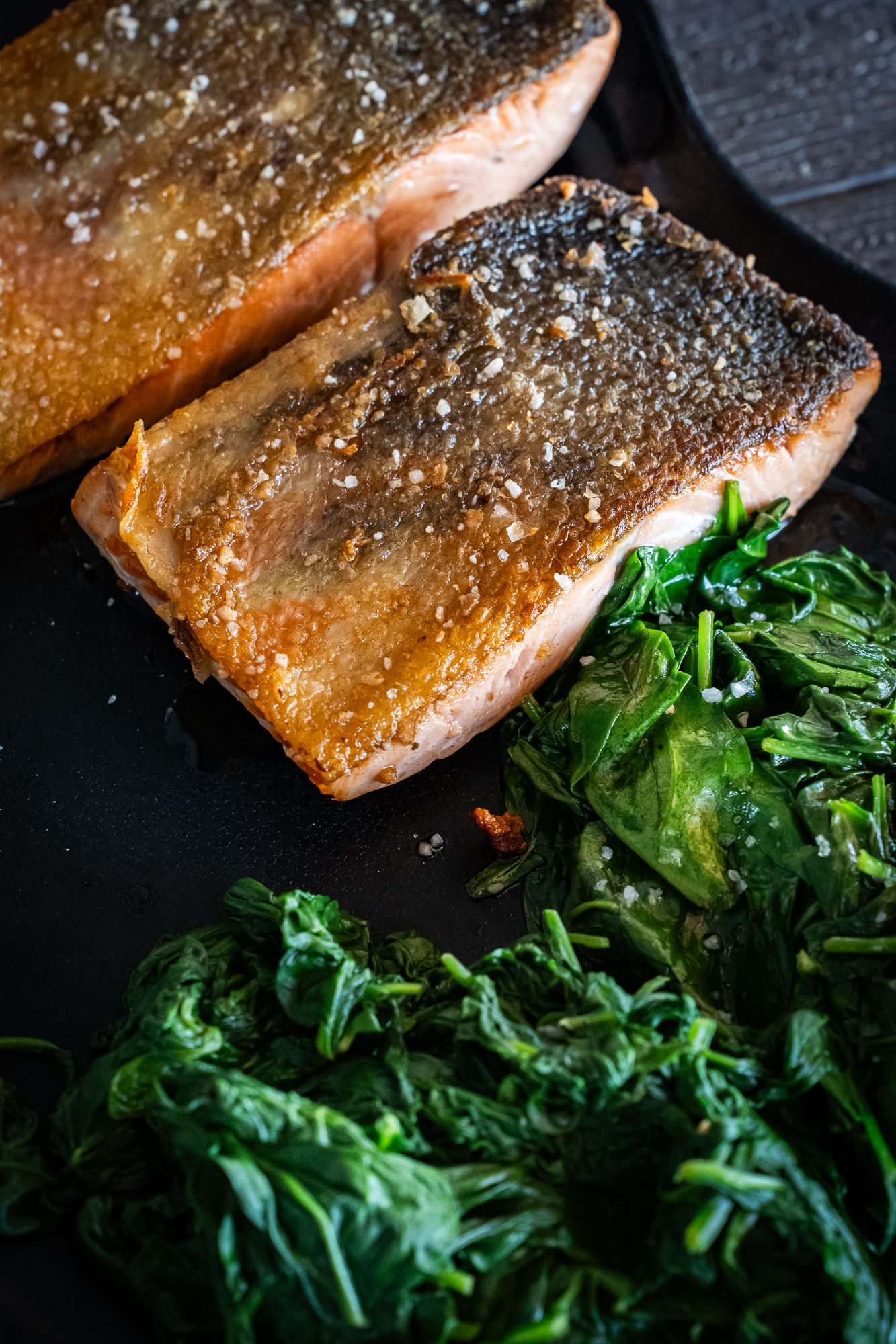 Lomos de salmón recién cocinados con espinacas salteadas